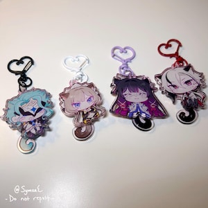 Puede incluir: Cuatro llaveros de acrílico con personajes de anime estilo chibi con rasgos felinos. Cada dije cuelga de un broche en forma de corazón en negro, blanco, lavanda o rojo. Los personajes tienen colores de cabello distintos que incluyen turquesa, marrón claro, morado oscuro y blanco.