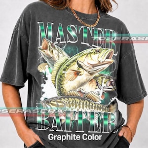 Könnte beinhalten: Ein anthrazitfarbenes Kurzarm-T-Shirt mit einem großen Grafikdruck von drei Forellenbarschen, die aus dem Wasser springen. Der Text "MASTER" steht über den Fischen und "BAITER" darunter, mit "Graphite Color" am unteren Rand gedruckt.