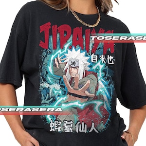 K&ouml;nnte beinhalten: Schwarzes T-Shirt mit einer Grafik eines Charakters mit wei&szlig;en Haaren und einem sternf&ouml;rmigen Kopfschmuck. Das Design enth&auml;lt den Namen "JIRAIYA" in Rot, japanischen Text und blaue Blitzeffekte. Das T-Shirt hat einen Vintage-Look.