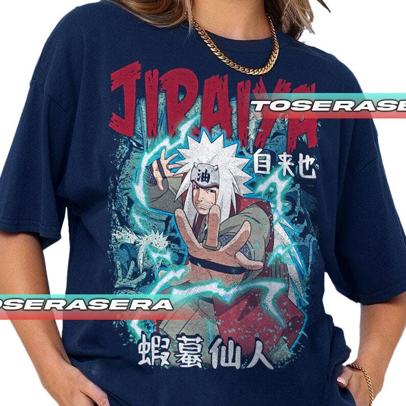 K&ouml;nnte beinhalten: Marineblaues T-Shirt mit einer Grafik eines Charakters mit wei&szlig;en Haaren und einem sternf&ouml;rmigen Kopfschmuck. Das Design enth&auml;lt japanischen Text und Blitzeffekte, mit dem Wort "JIRAIYA" in Rot. Das T-Shirt hat einen Vintage-Look.