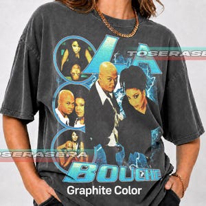 May include: Graphite-colored t-shirt featuring a graphic of the musical group La Bouche. The design includes portraits of the band members in blue circles and text that reads "LA BOUCHE". The shirt has a vintage, worn look.