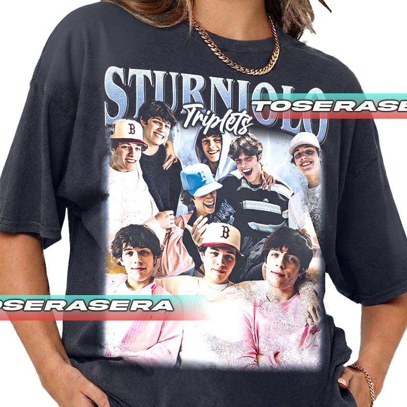 May include: Dark gray t-shirt featuring a graphic of several young men with the text "STURNIOLO Triplets" in a vintage style. The image includes a variety of colors and the t-shirt has a classic crew neck design.