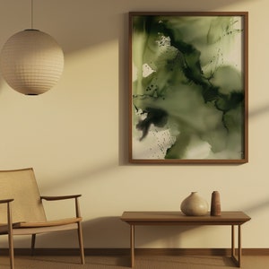 May include: A minimalist living room with a wooden chair, a coffee table, and a framed abstract painting with green and black watercolor washes. A round paper lantern hangs from the ceiling.