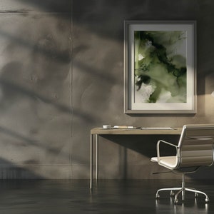 May include: A modern home office with a desk, chair, and lamp. A framed abstract painting with green and white colors hangs on the wall. The desk is made of wood and has a metal frame. The chair is made of metal and has a white leather seat. The lamp is made of metal and has a white shade.