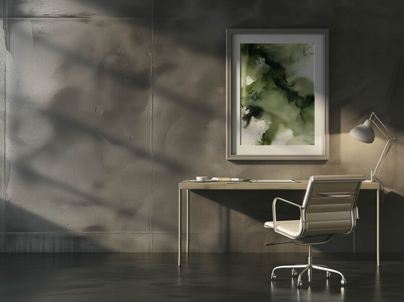 May include: A modern home office with a desk, chair, and lamp. A framed abstract painting with green and white colors hangs on the wall. The desk is made of wood and has a metal frame. The chair is made of metal and has a white leather seat. The lamp is made of metal and has a white shade.