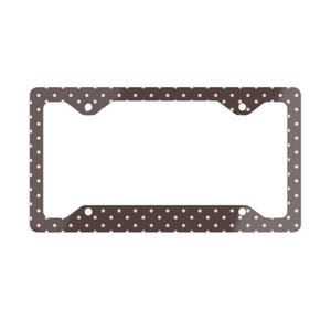 May include: A license plate frame with a dark brown background and a pattern of small, evenly spaced pink polka dots. The frame has a rectangular shape with rounded corners and mounting holes.