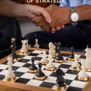 May include: A chessboard with black and white squares and chess pieces. The pieces are black and white with gold-colored bases. The image includes the text "GIFTS OF STRATEGY" and "FOR THE CHAMPIONS IN THE MAKING". Two people are shaking hands in the background.