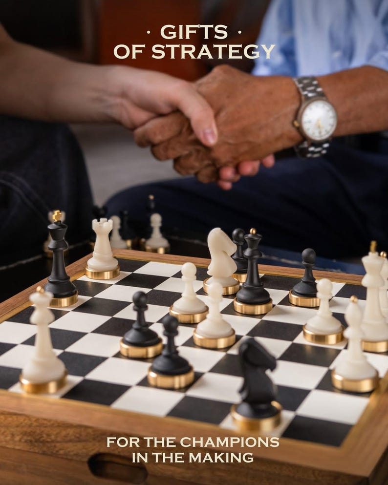 May include: A chessboard with black and white squares and chess pieces. The pieces are black and white with gold-colored bases. The image includes the text "GIFTS OF STRATEGY" and "FOR THE CHAMPIONS IN THE MAKING". Two people are shaking hands in the background.