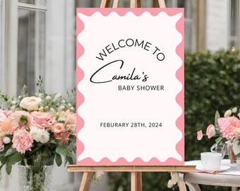 May include: Pink and white welcome sign with scalloped edges. The sign reads "Welcome to Camila's Baby Shower, February 28th, 2024".