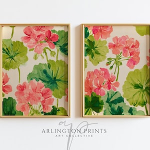 May include: Two framed floral prints featuring pink geraniums and green leaves against a cream background. The artwork is in gold frames. The text "ARLINGTON PRINTS ART COLLECTIVE" is at the bottom.