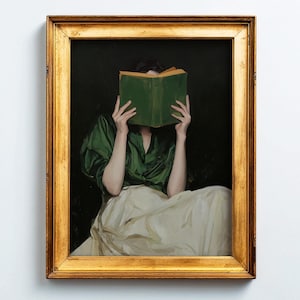 Peut inclure: Peinture encadrée d'une personne assise, un livre vert devant le visage. La personne porte une blouse verte et une jupe blanche. Le tableau est dans un cadre doré, sur un fond sombre et un mur blanc.