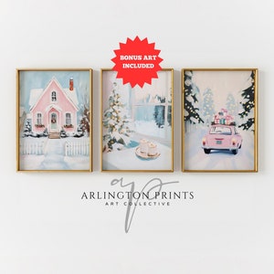 Puede incluir: Conjunto de tres láminas artísticas enmarcadas con escenas invernales. Una lámina muestra una casa rosa en la nieve, otra una ventana nevada con velas y la última un coche rosa con regalos. Los marcos son dorados. El arte está etiquetado como "BONUS ART INCLUDED".