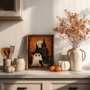 Vintage-style Halloween wall art featuring a cute ghost in a witch hat, a black cat with a glowing pumpkin, and a haunted house under a full moon. Perfect printable art for spooky and gothic Halloween decor.