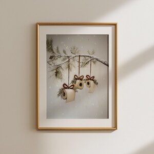 Funny Christmas bathroom print featuring toilet paper ornaments with red bows and greenery on a snowy pine branch, humorous holiday wall art digital download.