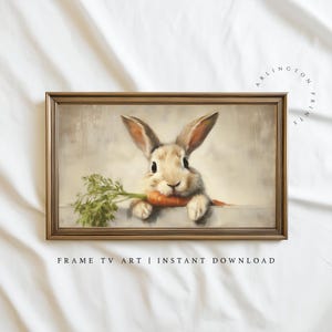 以下が含まれることがあります： ニンジンをくわえたウサギが描かれた額入りのプリント。柔らかい色合いとニュートラルな背景が特徴のヴィンテージ風アートです。下部には「FRAME TV ART | INSTANT DOWNLOAD」と書かれています。