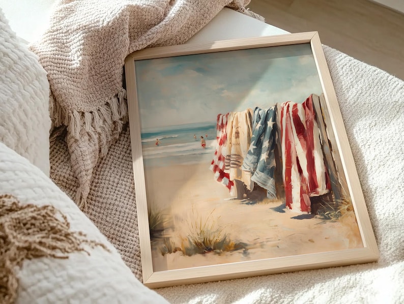 Beach scene with red, white, and blue towels hanging on a wooden fence, ocean waves and swimmers in the background. Coastal Americana style perfect for summer or 4th of July decor. Patriotic Beachy Wall Art, Coastal 4th of July PRINTABLE, Red White Blue Beach Towels, Vintage Summer Seaside Decor, Retro Americana Print