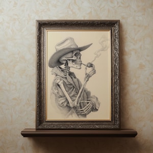 May include: A framed pencil drawing of a skeleton wearing a cowboy hat and coat, smoking a pipe. The artwork is in a dark wooden frame and is displayed on a dark brown shelf against a patterned wall.