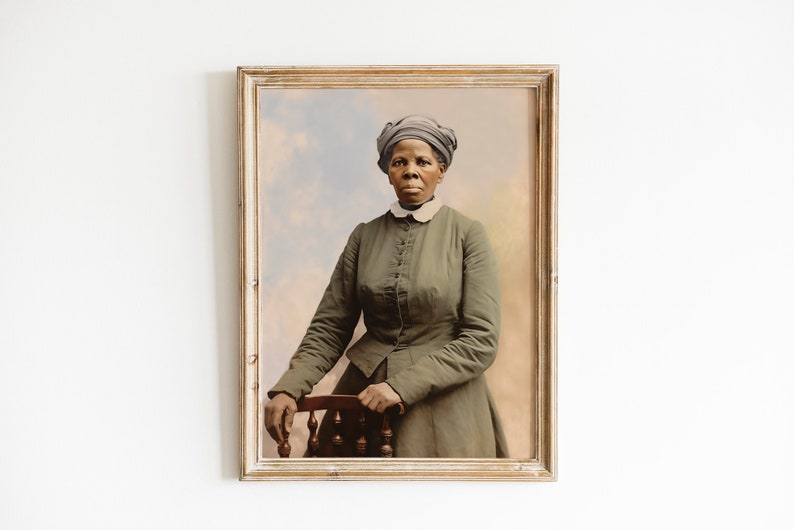 May include: Framed portrait of a woman in a green dress and head covering, resting her arm on a wooden chair. The portrait has a vintage aesthetic with a soft, colorful background. The frame is a light, distressed wood.