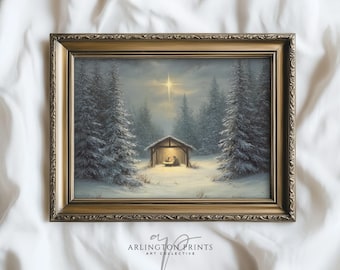 May include: A framed painting depicts a winter scene with a nativity scene in a wooden shelter, illuminated by a warm light. Snow-covered evergreen trees surround the shelter. A bright star shines in the sky above the scene. The frame is gold.