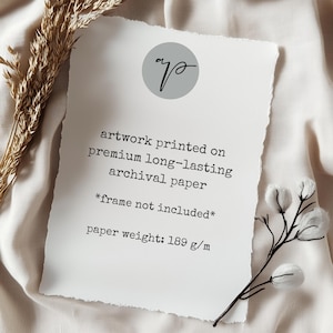 May include: A white artwork print with a torn edge, featuring text that reads "artwork printed on premium long-lasting archival paper". The paper weight is 189 g/m. A gray circle with a script logo is at the top.