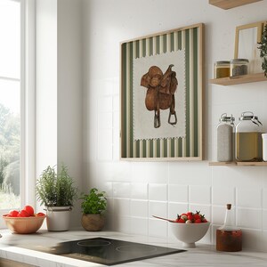 Printed Western wall art featuring a detailed illustration of a vintage leather cowboy saddle with stirrups, displayed on textured parchment-style paper with a striped green and cream background. Ideal for rustic home decor, ranch houses, barns, or cowboy-themed rooms. This artwork evokes classic Western heritage and equestrian charm, making it a perfect printed piece for lovers of country and cowboy style.