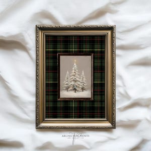 May include: Framed Christmas art print featuring a winter scene with snow-covered trees. The inner frame displays the artwork, set against a green and red plaid background within a gold-colored ornate frame. The print is from Arlington Prints Art Collective.