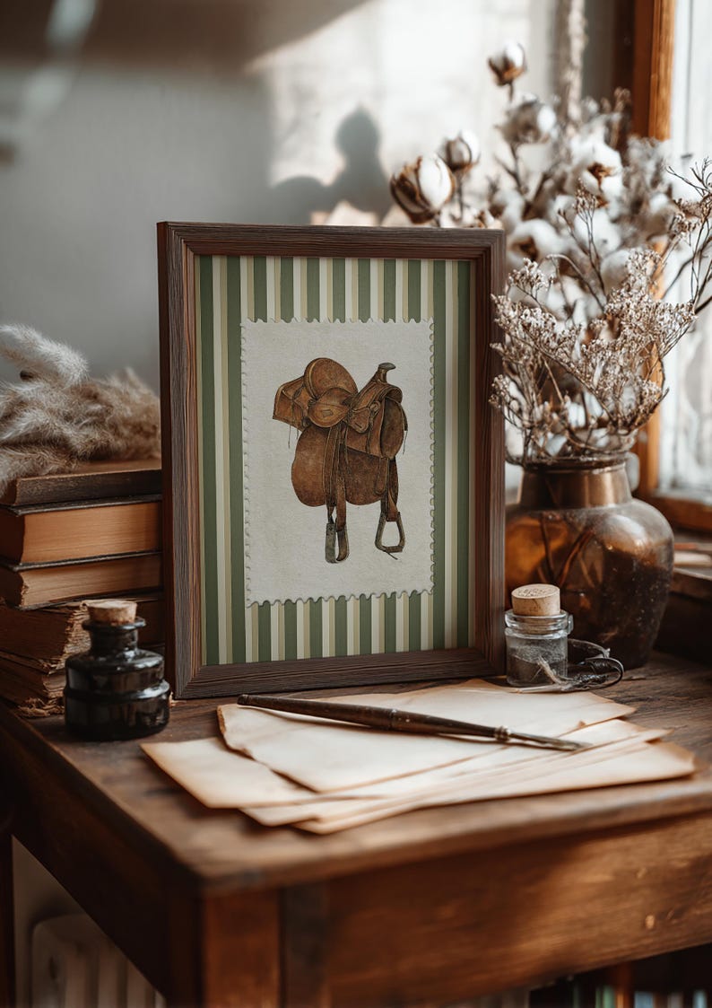 Printed Western wall art featuring a detailed illustration of a vintage leather cowboy saddle with stirrups, displayed on textured parchment-style paper with a striped green and cream background. Ideal for rustic home decor, ranch houses, barns, or cowboy-themed rooms. This artwork evokes classic Western heritage and equestrian charm, making it a perfect printed piece for lovers of country and cowboy style.