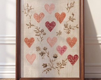May include: Framed artwork featuring a linen background with a pattern of hearts in shades of pink and red. Brown floral accents and a dark brown wooden frame complete the piece. The artwork is displayed on a wooden floor.