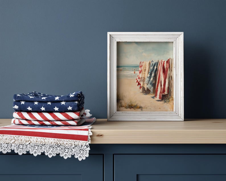 Beach scene with red, white, and blue towels hanging on a wooden fence, ocean waves and swimmers in the background. Coastal Americana style perfect for summer or 4th of July decor. Patriotic Beachy Wall Art, Coastal 4th of July PRINTABLE, Red White Blue Beach Towels, Vintage Summer Seaside Decor, Retro Americana Print