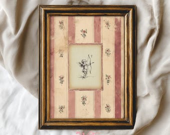 May include: Framed artwork featuring a vintage-style illustration of Cupid with a bow and arrow. The frame has a dark brown and gold finish. The background has a striped pattern with pink stripes and floral accents. The artwork is from Arlington Prints.