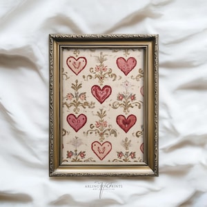May include: A framed print featuring a repeating pattern of red hearts and floral elements on a cream-colored background. The frame is gold-toned with ornate detailing. The print is labeled "ARLINGTON PRINTS ART COLLECTIVE".