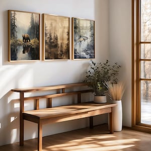 ustic wilderness-themed gallery wall featuring digital paintings of a bear by a lake, a crow on a branch, deer in misty woods, a cabin by the water, a leaping fish, and a foggy forest. Earthy tones and moody lighting create a serene, nature-inspired aesthetic perfect for lodge, cabin, or modern rustic decor.
