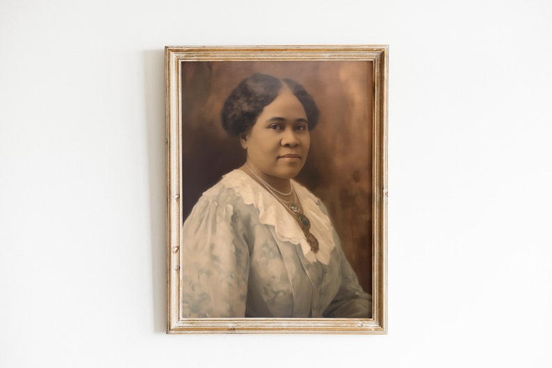 May include: A framed portrait of a woman with dark hair and a light blue dress with a white lace collar. The portrait is in a vintage-style, light-colored wooden frame, hanging on a white wall. The image has a sepia tone.