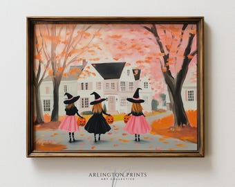 May include: A framed art print featuring three figures in witch hats and skirts walking toward a white house. The scene includes orange autumn trees, fallen leaves, and each figure carries a small orange jack-o'-lantern bucket for trick-or-treating.