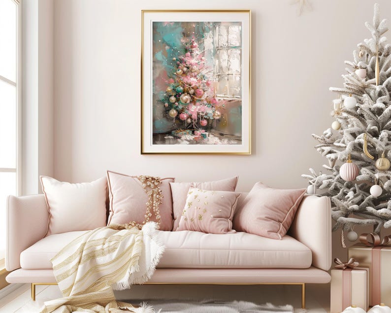 May include: A pink and white sofa with gold throw pillows and a blanket. A framed painting of a pink and green Christmas tree with ornaments hangs on the wall behind the sofa. A white flocked Christmas tree with ornaments is in the background.