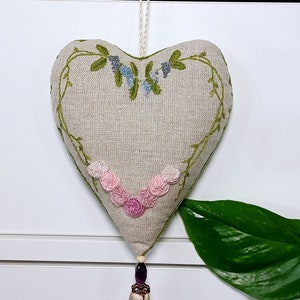 Hand embroidered linen sachet with tassel and hanging loop filled with lavender hanged on drawer knob