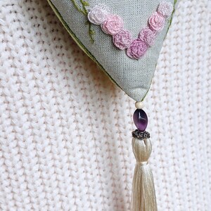 Hand embroidered linen sachet with tassel and hanging loop filled with lavender hanged on clothes hanger