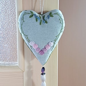 Hand embroidered linen sachet with tassel and hanging loop filled with lavender hanged on door hanger