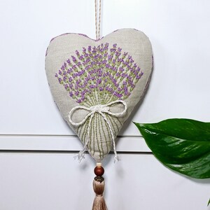 Handmade hand embroidered heart shaped linen sachet with hanging loop and tassel filled with lavender. Hung on drawer knob. Embroidered lavenders.
