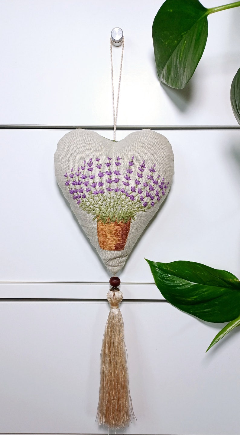 Linen handmade hand embroidered heart shaped sachet with tassel and hanging loop, filled with lavender. Finished embroidery. Embroidered pot with lavenders.