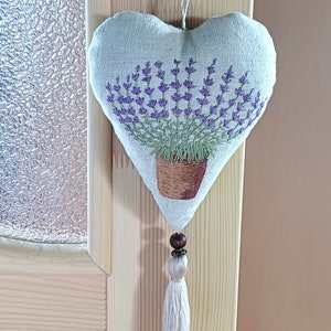 Linen handmade hand embroidered heart shaped sachet with tassel and hanging loop, filled with lavender. Finished embroidery. Embroidered pot with lavenders.