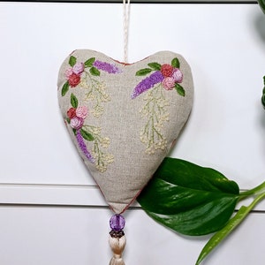 Handmade embroidered linen heart shaped home decor sachet, with hanging loop and tassel. Hung on a drawer knob.