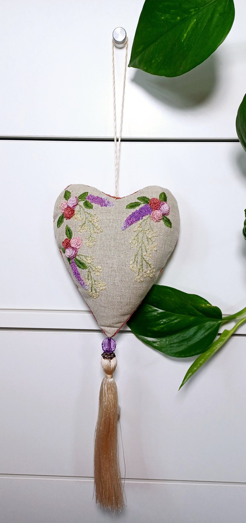 Handmade embroidered linen heart shaped home decor sachet, with hanging loop and tassel. Hung on a drawer knob.