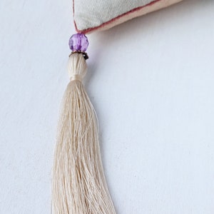 Handmade embroidered linen heart shaped home decor sachet, with hanging loop and tassel.