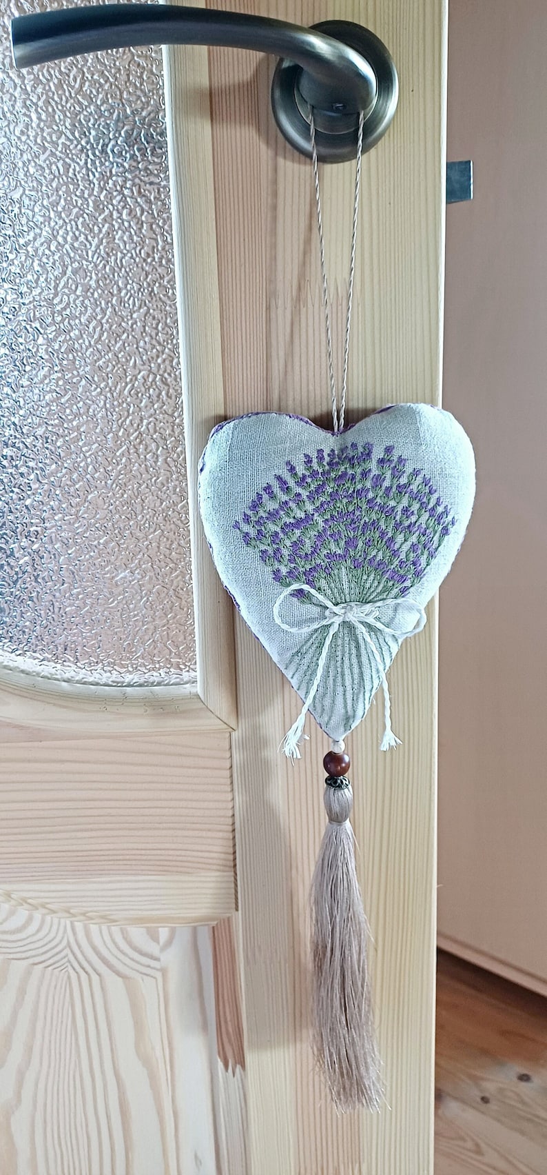 Handmade hand embroidered heart shaped linen sachet with hanging loop and tassel filled with lavender. Hung on door hanger. Embroidered lavenders.