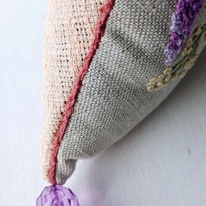 Handmade embroidered linen heart shaped home decor sachet, with hanging loop and tassel.