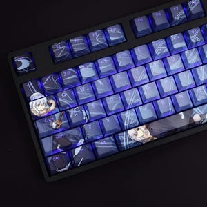 May include: A keyboard with blue and white keys featuring anime characters. The keys are backlit with a purple glow. The keyboard has a black frame and a black background.