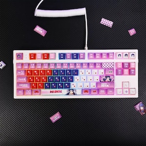 May include: A white mechanical keyboard with pink and blue keycaps. The keyboard has a custom keycap set with a pink and blue gradient and a character from an anime on the space bar. The keyboard also has a white cable.