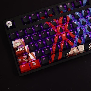 May include: A black mechanical keyboard with custom keycaps featuring anime characters. The keycaps are red, white, and blue with a black and white striped pattern. The keyboard has a purple backlight.