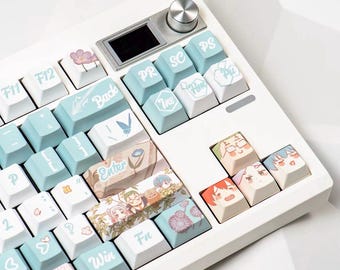 May include: A white mechanical keyboard with custom keycaps. The keycaps are a mix of light blue and white, with various illustrations and text. The keyboard has a small screen and a silver dial. The keycaps feature floral and anime-style designs.